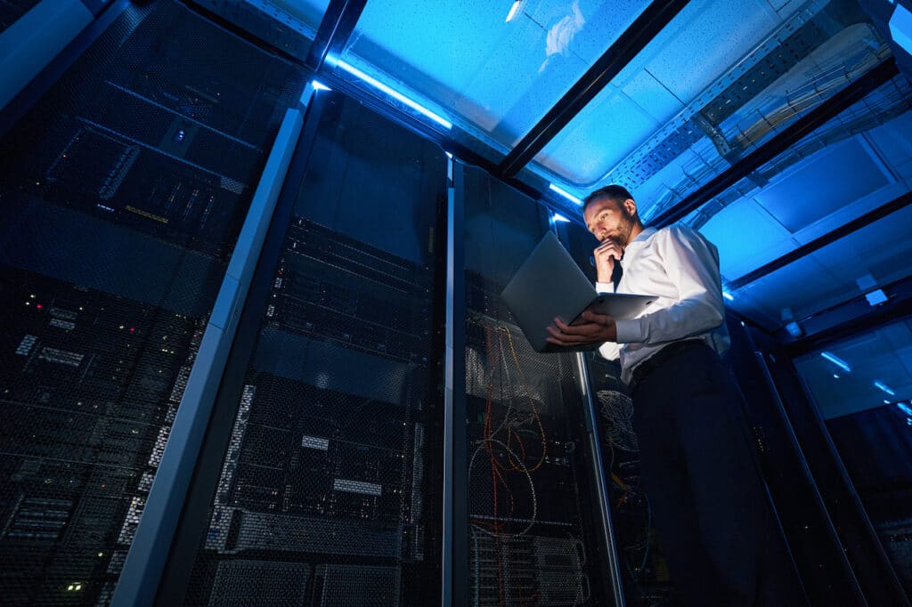 male IT specialist in server room implementing digitization within a company's systems